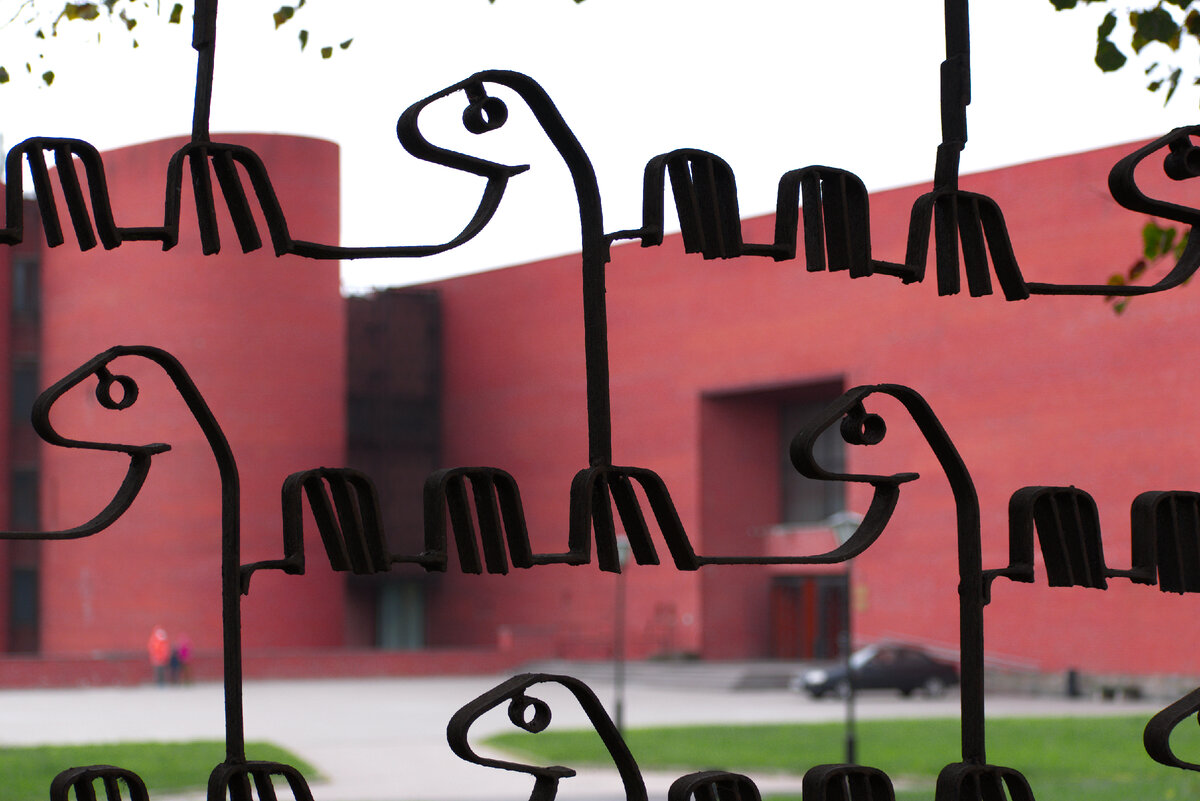 Вроде ничего особенного — всего-то выкрашенный чёрной краской забор из стального полотна сваренного в форме динозавра. Столичный житель так привык к типовым конструкциям, что взгляд к этой простой, но интересной форме цепляется моментально, стоит только его заметить.