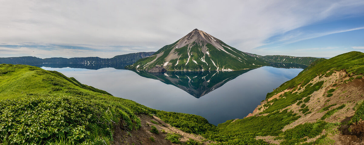 Вулкан и небо над ним отражается в озере.