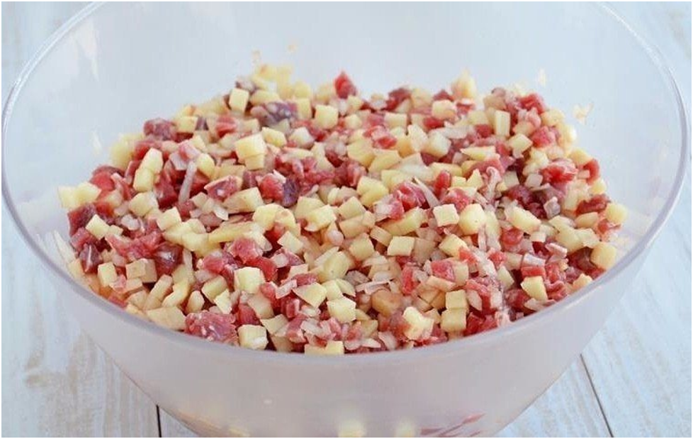 2. Для начинки говядину и картофель порезать кубиками, лук порубить мелко, посолить, поперчить, хорошенько перемешать.