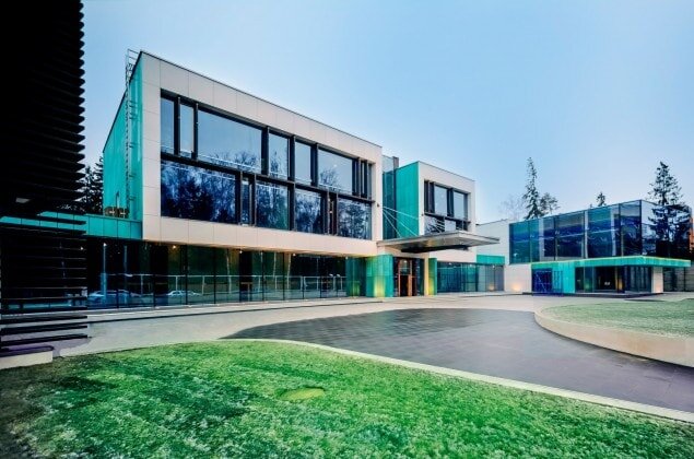 
Футуристический дизайн здания в Успенском лесу сразу приковывает к себе внимание. Десятиметровые кедры, окружающие дом в стиле «хай-тек», только усиливают общий контраст с природой.