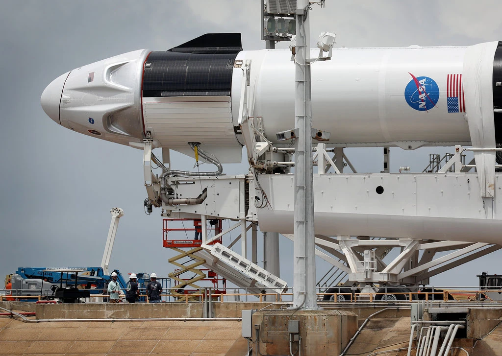 Workers on Tuesday prepared the SpaceX Falcon 9 rocket and Crew Dragon spacecraft for launch at Cape Canaveral, Fla.Credit...Joe Raedle/Getty Images