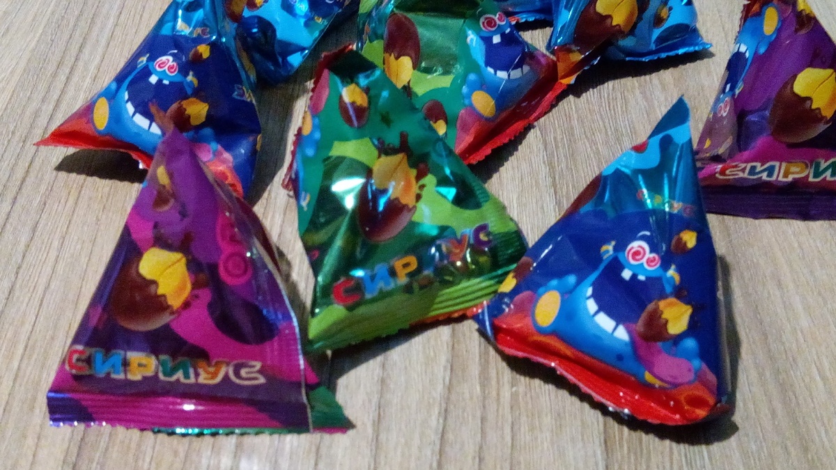 Упакованы такими пирамидками. Цвет ни на что не влияет, везде одинаковые конфеты.