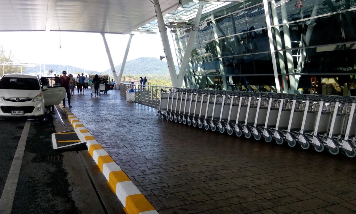 Многочисленные багажные тележки, которых обычно днем с огнем не сыщешь, стоят стройными рядами