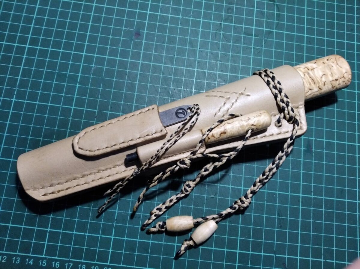 Вид ножа со стороны зажигалки. Черненький стержень огниво, маленький металлический ножичек кресало. Можно разжигать костер в любую погоду.