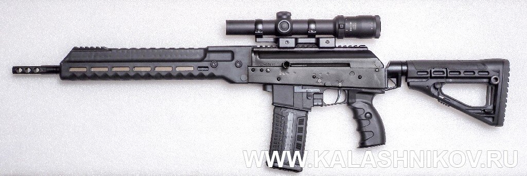 Самозарядный карабин со сбалансированной автоматикой «Сайга-107»/SR1 калибра .223 Rem. с прицелом «Дедал» DH 1-7х24. Карабин оснащён оригинальным цевьём, полностью скрывающим детали газового двигателя и приёмником под AR-магазины с двусторонними кнопками затворной задержки и защёлки магазина. Съёмная крышка ствольной коробки оснащена планкой «пикатини» 