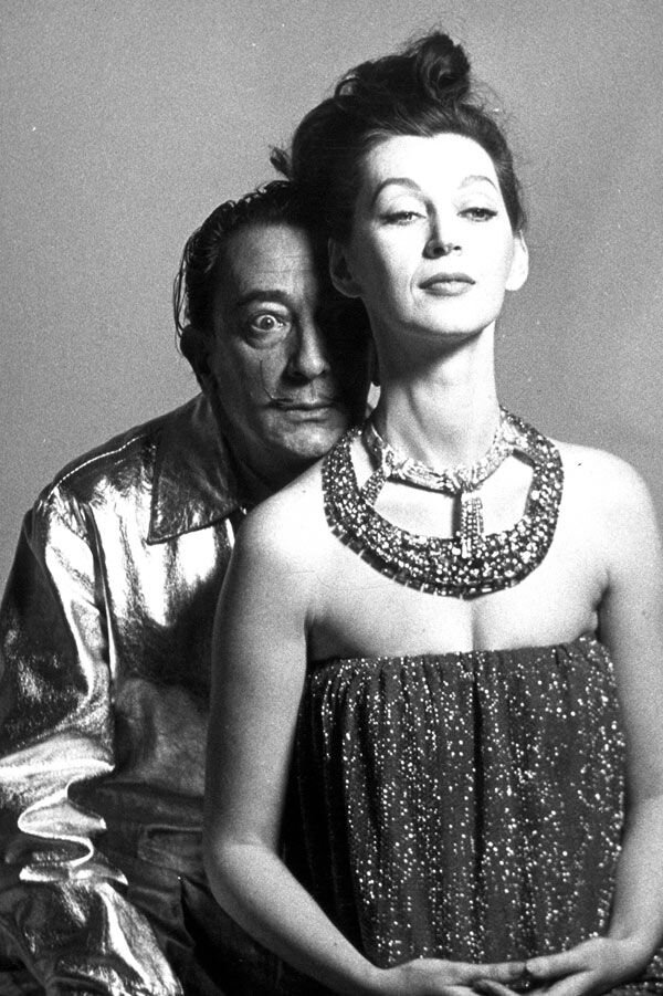 Дали и, казалось бы Гала. Но нет, это модель Довима. Фотографируясь для рекламы браслета Дали "Фонтан Гераклита"в журнале Harper's Bazaar, Дали выбрал тот же тип женщины, как и Гала. 
  У Сальвадора Дали не было выбора кем стать. Он не был нормальным человеком, хладнокровно играющим фигляра. Он сам был кораблем, носимым по воле штормового ветра своей не-вполне-нормальности.
     Только встретив Галу, встретив такую же не очень нормальную женщину, только очень сильную и практичную, получив от нее удар "как пушечным ядром", Дали пришел в себя. 