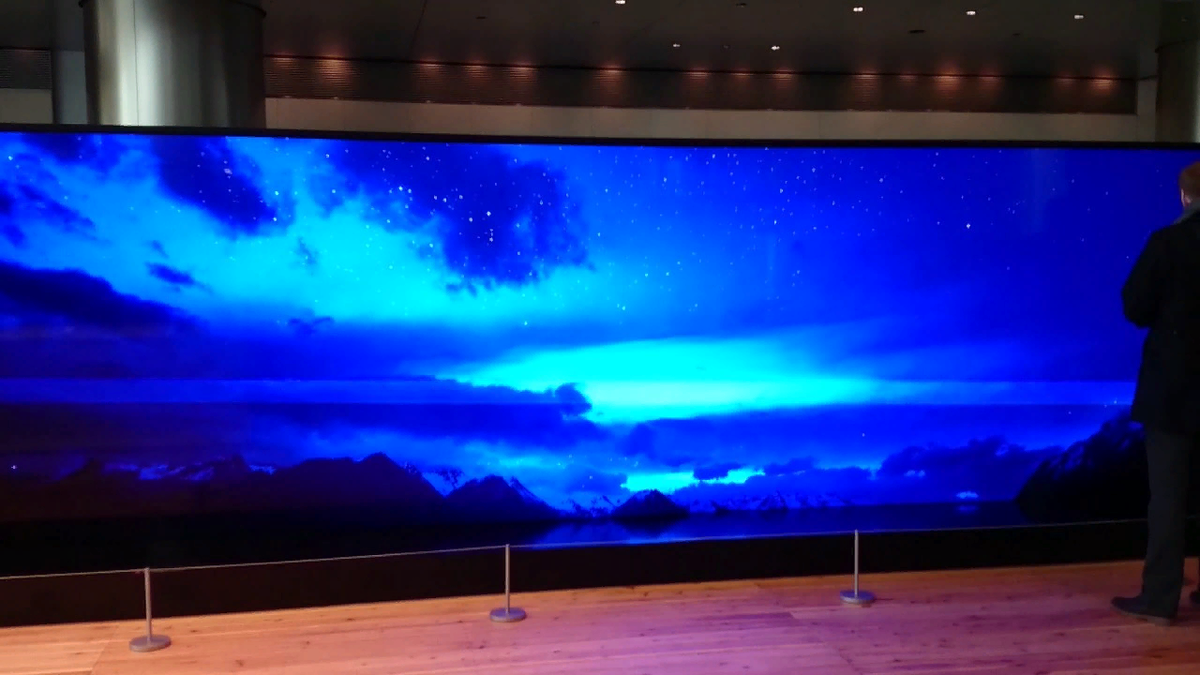 Некоторое время назад компания Sony представила другую разработку — огромный модульный экран без видимых граней и стыков. Устройство представляет собой совокупность множества блоков размером 16 х 18 дюймов. От количества элементов зависит размер и разрешение экрана. Например, для разрешения 1080p требуется 18 модулей, 4K — 72 модуля, 8K — 288 модулей, 16K — 576 модулей. Выставочный образец высотой с двухэтажный дом имеет размеры 19,2 на 5,4 метра. 
Технические характеристики включают 10-битную цветопередачу, яркость 1000 нит, угол обзора 180 градусов, цветовой охват sRGB 140 % и поддержку HDR. Sony предлагает свое устройство не только корпоративным клиентам, но и обычным (ну, почти обычным) пользователям. Уже начиная с 4К цена телевизора пугает. Так как один элемент обойдется потенциальному покупателю в 10 000 долларов, стоимость собранной Sony Crystal LED может доходить почти до 6 миллионов долларов. Подозреваем, что за эти деньги можно купить неплохой тропический остров.