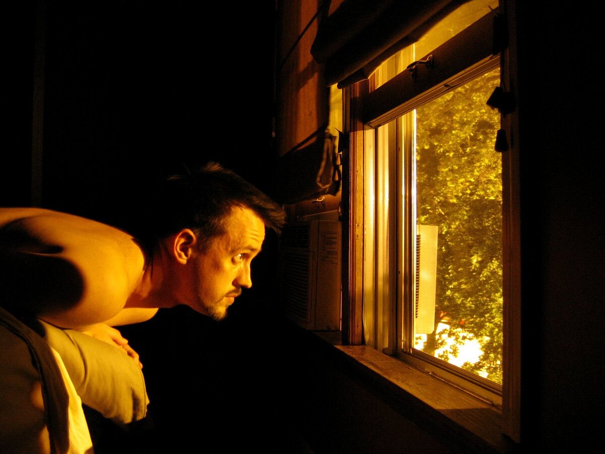 Мужчина заглядывает в окно