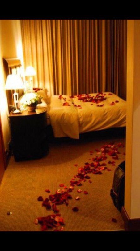 Романтик с лепестками роз на кровати фото