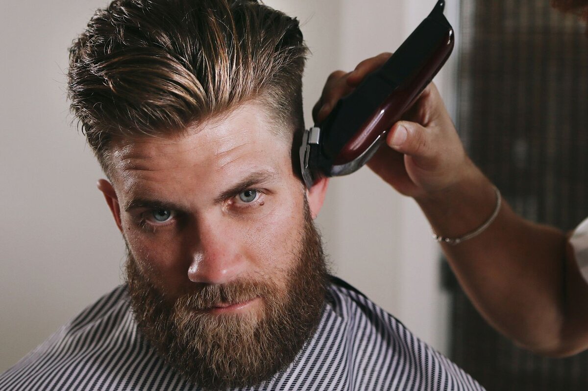Мужчина стрижет волосы мужчине