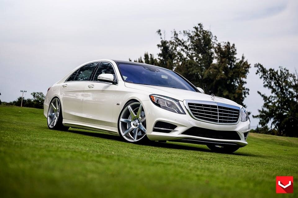 Mercedes S-class 2017 года обновляется, не успев устареть. Флагман является воплощением передовых технологий. Конструкторы реализуют триединую философию: интеллектуальное движение, экономичные технологии, квинтэссенция роскоши. Текущая модель W 222 заменила собой W 221 и является элитарной продукцией автоконцерна.
Рестайлинг 2017 года Мерседеса 222 это не текущая плановая модернизация, а комплемент от бренда. Совершенный автомобиль не нуждается в усовершенствованиях. И, тем не менее, инженеры, конструкторы и дизайнеры нашли возможность реализовать безудержный полет творческой мысли. Материалом кузова и силового каркаса являются новейшие сплавы высокопрочной стали, алюминия, углепластика и конструкционного пенопласта. Дизайнеры из Штутгарта планомерно отходят от аутентичной архитектуры брутальных линий кузова и оптики кормовой части. Перспективным трендом является «ягуароподобное» закругление кормы. Эстетичный внешний вид стал более стремительным. Чередование вогнутых поверхностей и плавных граней даже в состоянии покоя автомобиля создают эффект динамики. Обширная зона остекления в боковой проекции обведена хромированным молдингом. Подоконная линия не вздергивается вверх, как у менее именитых брендов, а, наоборот, понижается к корме.
Изменения коснулись формы бамперов и облика радиаторной решетки. Хромированную облицовку украшают три горизонтальные и одна вертикальная перекладины. Mercedes S-class 2017 года является первым в мире автомобилем без единой лампы накаливания. Все оптические приборы внешнего и внутреннего освещения изготовлены с применением LED технологии. Всего использовано более 500 светодиодов. Каждая из фар головного света содержит 56 светодиодных элементов, ниспадающими тремя линиями водопада светодиодных полосок. Высокопроизводительные динамические фары оснащены функцией Intelligent Light System. Специальную подсветку имеет фирменная надпись «Mercedes-Benz» на плафонах. Элементы задних фонарей выполнены в виде языков пламени.