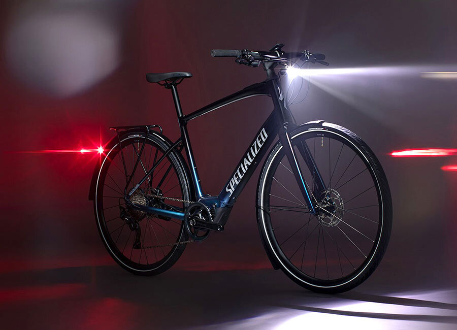 Городской велосипед Specialized Vado SL выполнен на основе рамы из алюминиевого сплава и оборудован крыльями, багажником и световыми приборами спереди и сзади. 