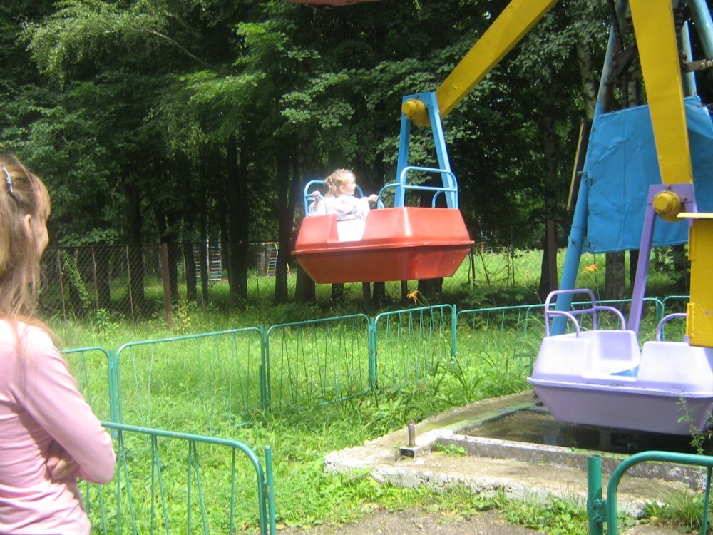 Фотография 2009-го года. В гостях у бабушки с дедушкой. Смотрю, как дочка на каруселях катается.