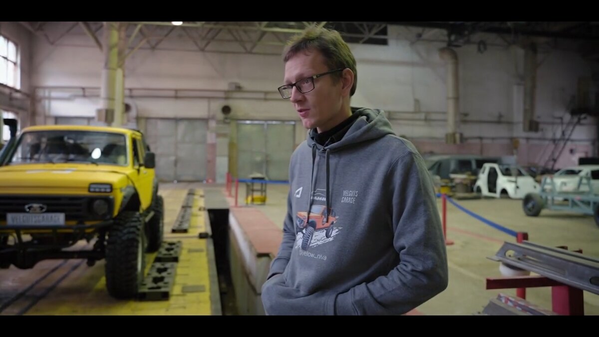 На фоне так же присутствует кузов какого-то седана, точно так же практически разобран.