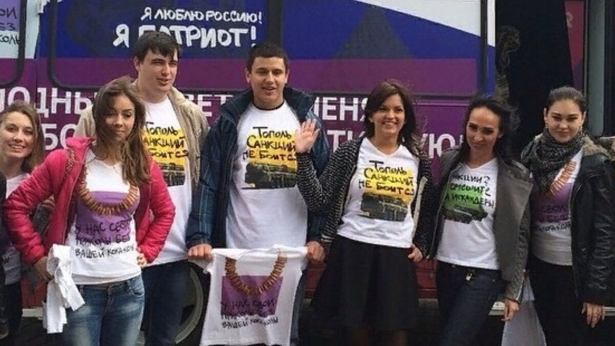 Молодые люди, лояльные российской власти, в футболках с надписями: "Тополь санкций не боится", "Санкции? Не смешите мои искандеры". В данном контексте "Тополь" и "Искандеры" - наши оперативно-тактические ракетные комплексы.