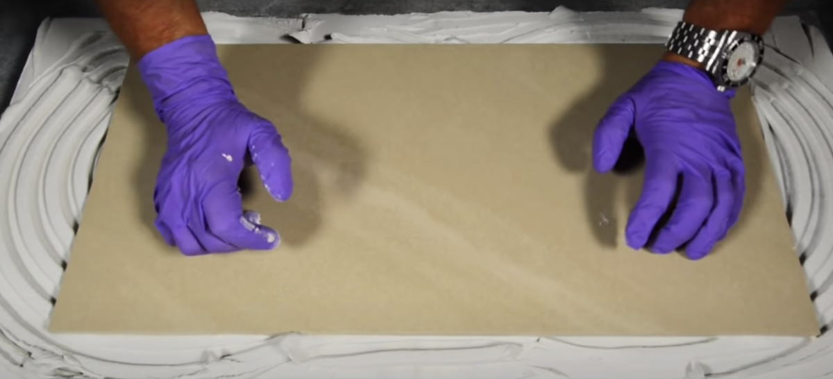 Пример неправильной укладки плитки. Клей нанесен волнообразно.