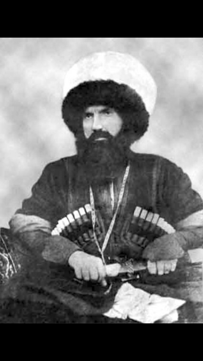 Перед вами самая первая фотография имама, которая была сделана в 1859 году. С ней связана интересная история.  
Фотографию сделал граф Иван Григорьевич Ностиц в дагестанской крепости Чир-Юрт. Именно туда и доставили пленного имама в августе 1859 года. Граф был командиром Нижегородского драгунского полка и страстным любителем фотографии. Ему очень хотелось запечатлеть Шамиля, имам не понимал, что от него хотят (ведь фотография только появилась и была диковинкой), но из вежливости к гостеприимному хозяину согласился. 
Портрет получился очень живой: имам грозно смотрит в сторону фотографа и наполовину обнажил свой кинжал. Дело в том, что Шамиль в этот момент решил, что русские решили его убить и собирался недёшево продать свою жизнь. Он воспринял фотоаппарат как какое-то новое оружие, которое направили на него. Ситуацию накаляло и то, что место съёмки окружили солдаты с ружьями наперевес, которым было интересно взглянуть на легендарного предводителя горцев. Граф, увидев, что сейчас может случиться что-то непоправимое, отослал солдат прочь. Имам же, поняв, что произошло недоразумение, успокоился. 