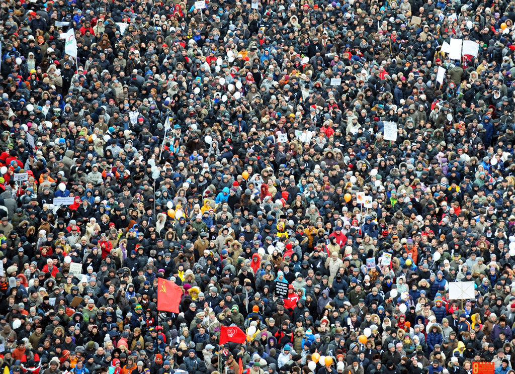 Огромная толпа народа вела по улице. Митинг много людей. Много людей на площади. Центр толпы. Скопление маленьких в виде флага.