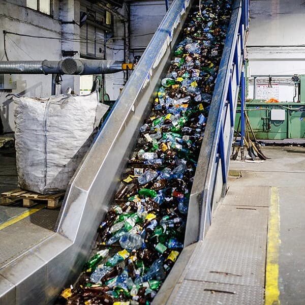Конвейер направляет ПЭТ бутылки на дробление