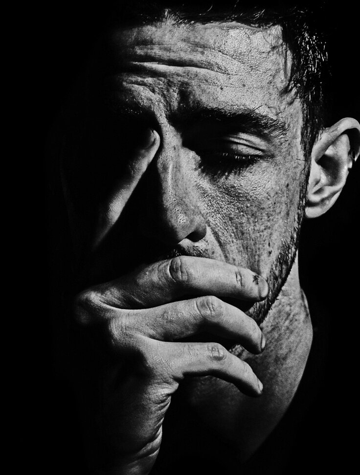 одинокий человек. мужчина держится за голову. это одиночество. человек в безысходности. большой отчаяние.