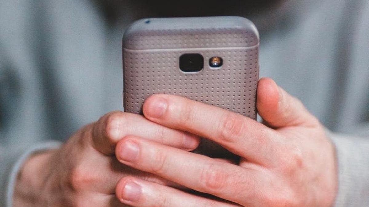    Мужчина держит в руках телефон:pexels.com