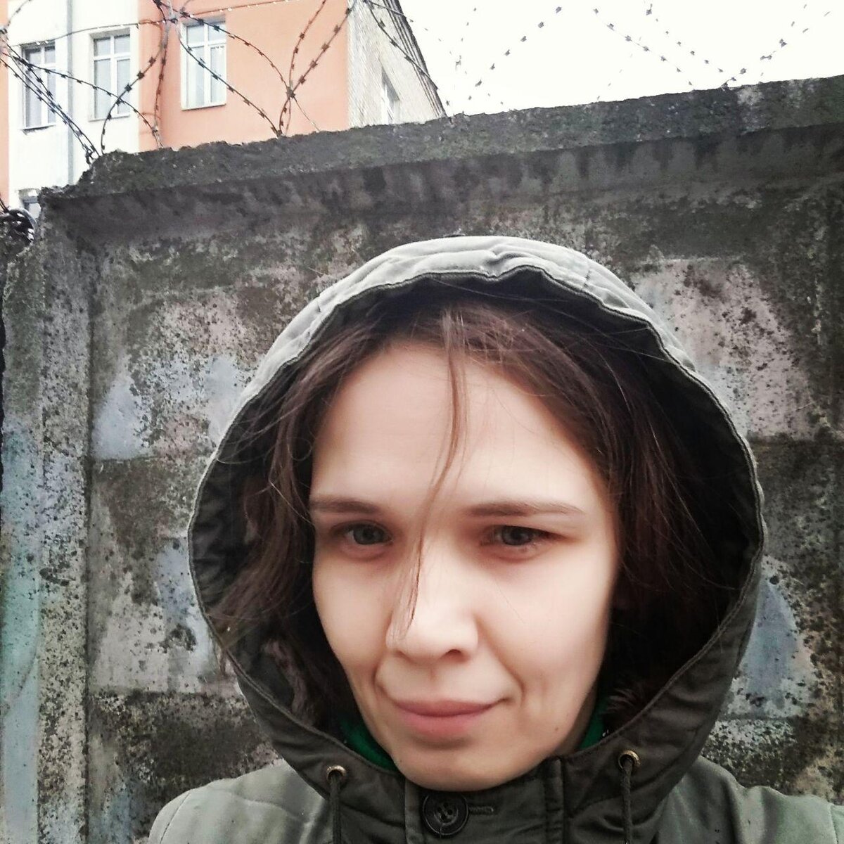 Замшелая бетонная стена и человек, почти сливающийся с ней