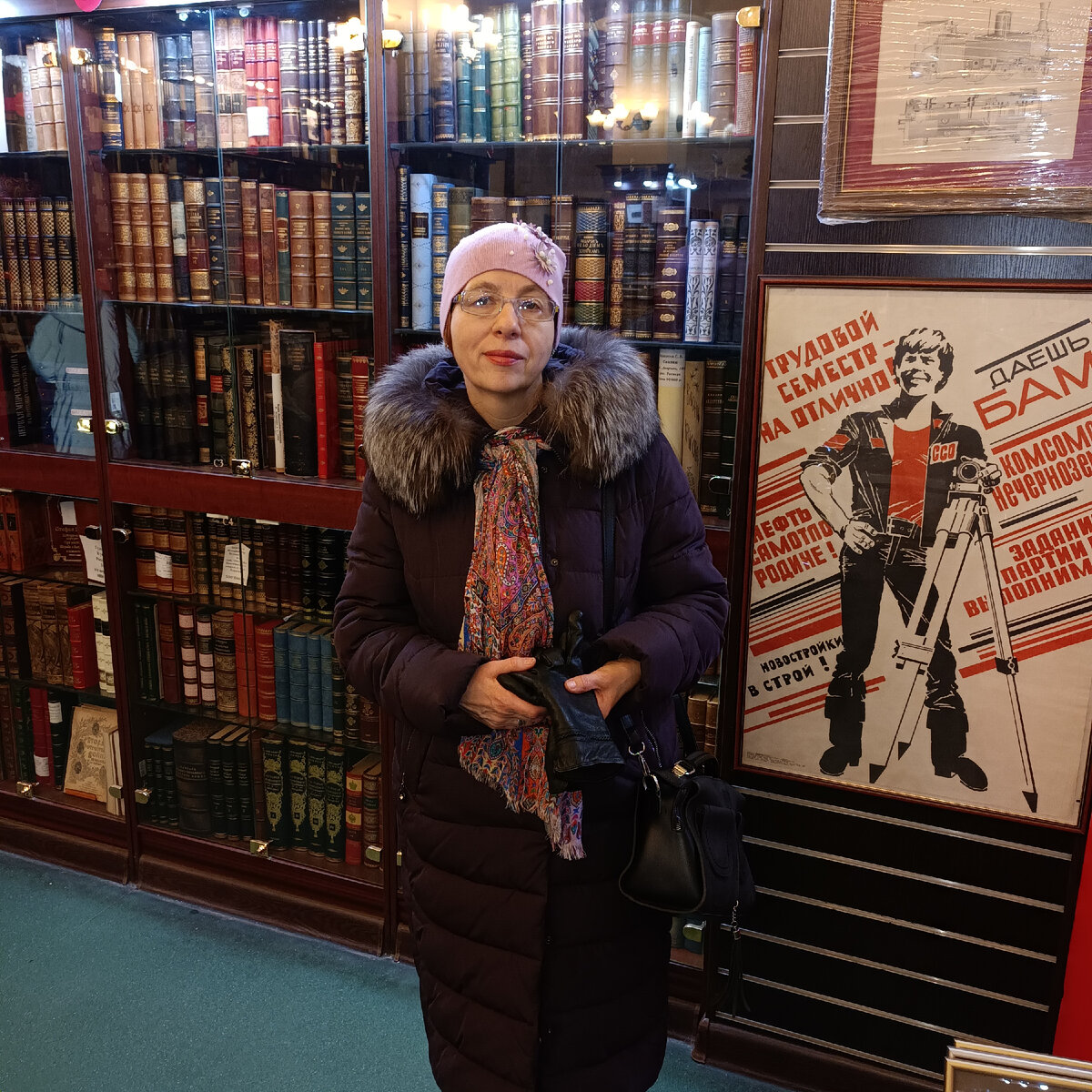 На фоне плаката времен СССР.