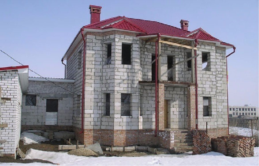 Построив дом из пеноблоков получаем такие плюсы:

Уменьшается давление на фундамент (низкий вес материала).

Экономия смеси, на которую производится кладка. Можно обойтись простой шпаклевкой стен, без штукатурки.

Трудоемкость работ уменьшается в разы, так как вместо 15 — 20 кирпичей укладываем — 1 пеноблок. Вес 15 кирпичей около 80 кг, а пеноблок весит — 15 кг.

Дом из ячеистого бетона удовлетворяет все нормы и требования по звукоизоляции. Увеличив плотность пенобетона возрастут и звукоизоляционные параметры.

Экологическими свойствами этот материал похож на дерево. Он дышит, поддерживая оптимальную влажность в помещении. В отличии от дерева, пенобетон не гниет и не горит, не ржавеет как металл.

В нем заключены свойства дерева и камня одновременно. Блоки из пенобетона производятся из натурального сырья, в которых не содержатся канцерогенные и радиоактивные вещества, тяжелые металлы, полимерных смолы и синтетики.

Микроклимат схож с микроклиматом деревянного дома: зимой — тепло и уютно, в жару — прохладно и комфортно. Пенобетон относится к негорючим материалам.

Может использоваться в качестве теплоизолятора при очень высоких температурах изолируемых поверхностей (до + 400 градусов Цельсия). Пенобетон легко обрабатывается ручным инструментом, который имеется в каждом доме.

С помощью электродрели (применяя подходящие насадки) можно вырезать канал для водопровода, под электро проводку и углубления под розетки. Пилой вырезаются дверные проемы и ниши любой формы.

С помощью рубанка сглаживаются все неровности на поверхности.

☝ Недостатки пенобетонных блоков.

Как и всякому строительному материалу, пеноблоку присущи и недостатки, о которых должен знать строитель. Пенобетонные блоки хрупкие.

Рекомендуется делать жесткий фундамент (свайный или ленточный). Каждые 3 ряда необходимо армировать стену. Пенобетон хорошо впитывает влагу. Что снижает его теплосберегающие характеристики.

Во избежание отсыревания стен следует создавать влагостойкую защиту и гидроизоляцию между стенами и фундаментом. Паропроницаемость блоков. Тут необходимо использовать снаружи пароизоляцию, для защиты от дождей.

Неточная геометрия пеноблока, получаемая в результате применения некачественных форм (производство материала мелкими производителями).

Не удивляйтесь расхождению в размерах на 2 — 3 см, что естественно скажется на толщине шва. От этого также зависит теплопроводность и фасад здания.