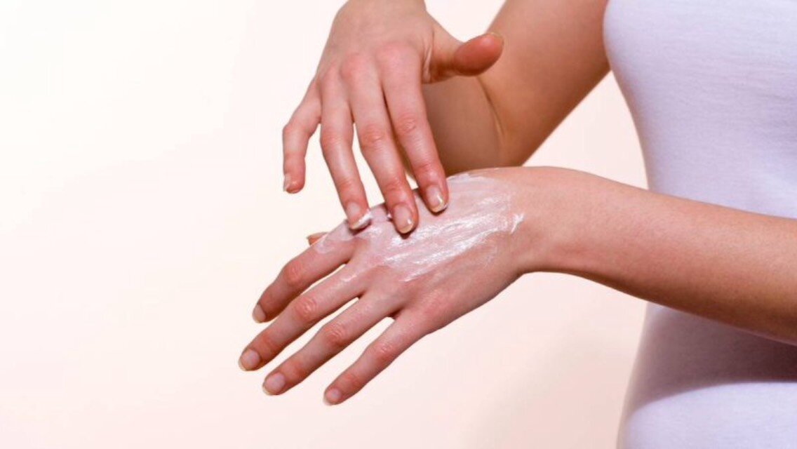 Лечение руками человека. Нанесение крема на кожу рук. Втирание мази. Крем для рук.