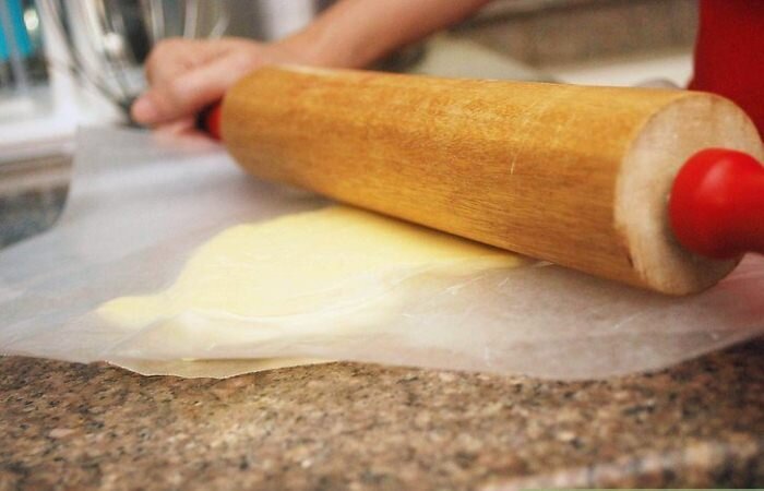 Положите масло на пергамент и пройдитесь по нем скалкой.