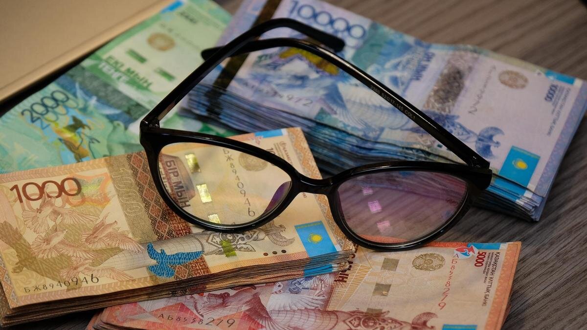    Очки лежат на пачках тенге:NUR.KZ/Владимир Третьяков