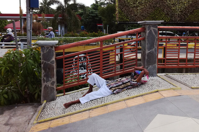 Почтовое отделение закрыто, ожидающий его открытия удобно расположился на камнях напротив офиса. Индонезия