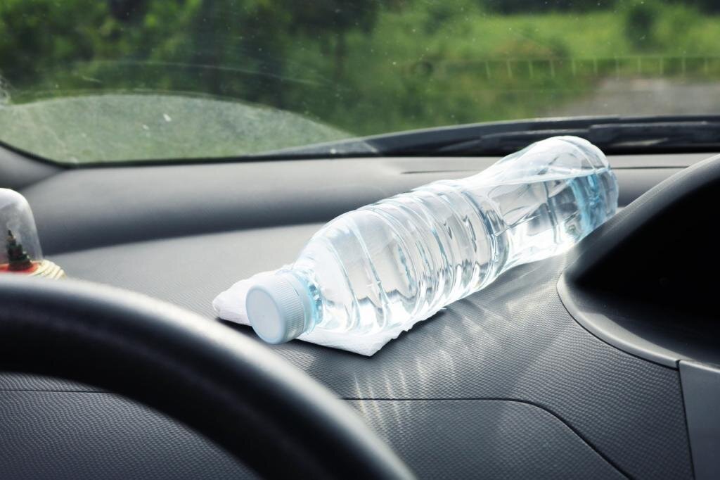 Бутылка воды в машине. Бутылка в салоне автомобиля. Бутылки пластиковые в автомобиле. Бутылочки воды в салоне автомобиля. Почему нельзя оставлять бутылки на столе