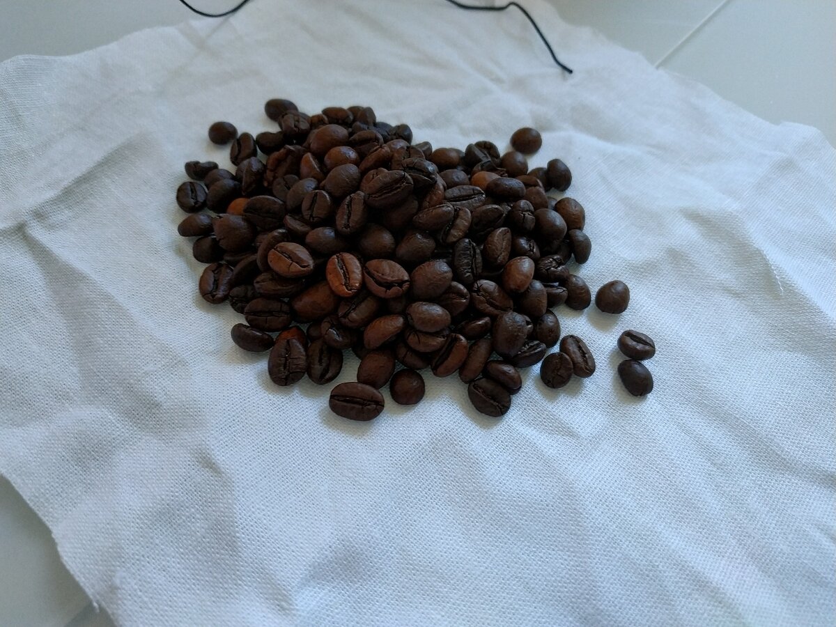 Завернуть, завязать и положить в машине на пару дней - кофе за это время впитает неприятные запахи, главное устранить их источник перед этим