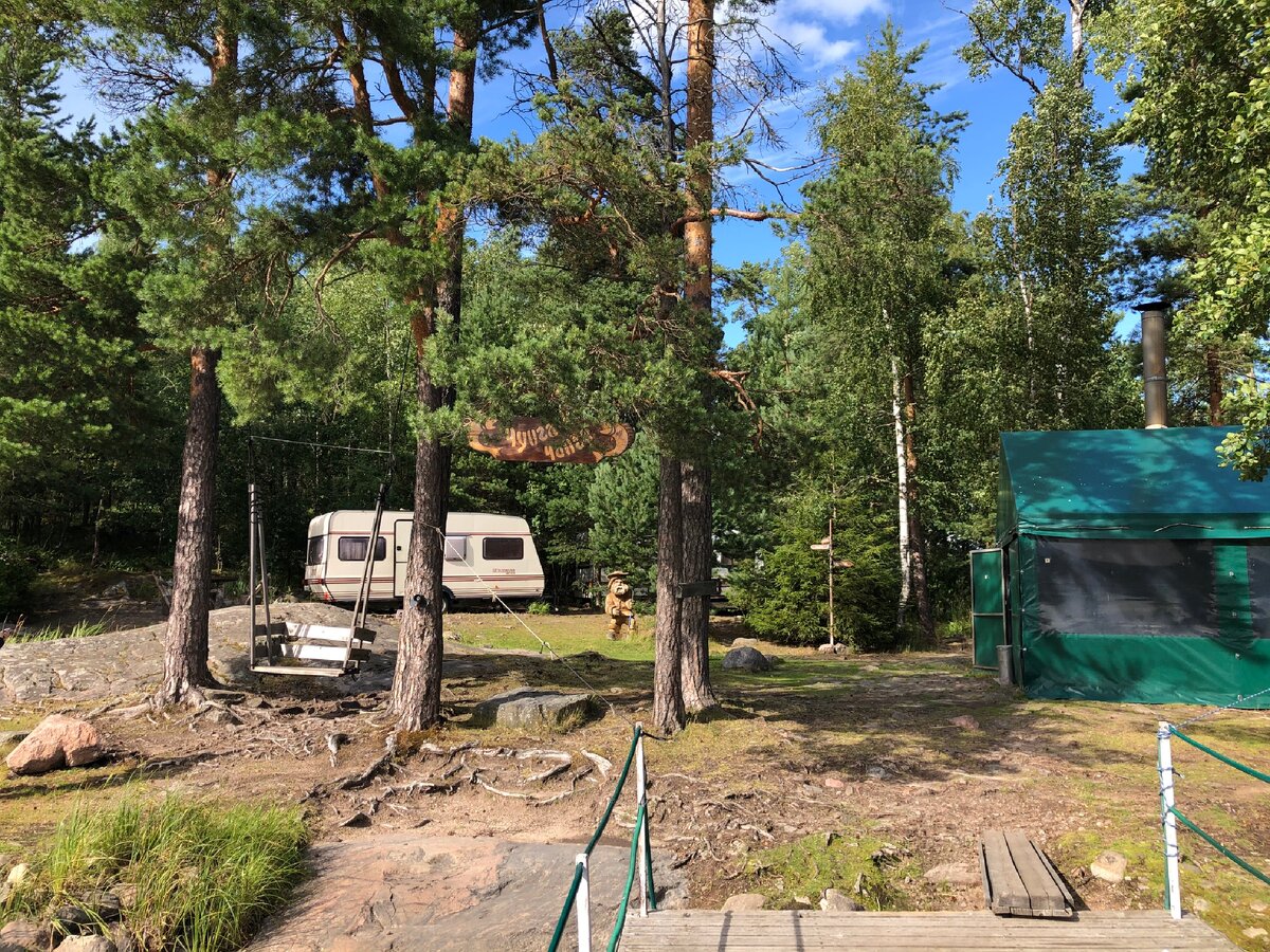 Вот такой приветливый вид открылся перед нами с понтона. Слева направо: ветхие качели, табличка с названием острова, на заднем плане один из двух трейлеров, деревянная статуя местного старожилы, шатер-кухня.