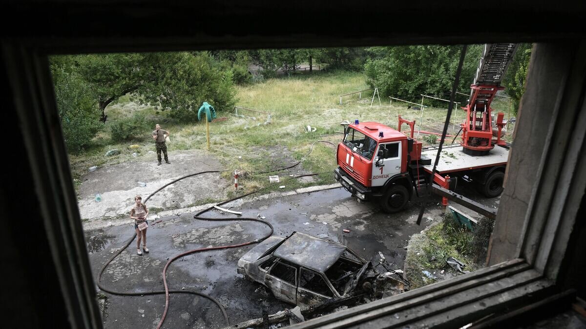    Машина МЧС ДНР возле дома, где возник пожар в результате обстрелов со стороны ВСУ Донецка© РИА Новости / Константин Михальчевский