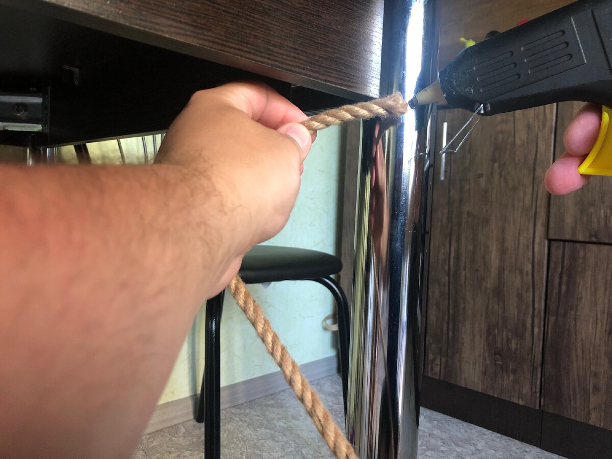 Фиксируем начало веревки клеем, вверху ножки и начинаем обматывать ее вокруг ножки по направлению вниз.