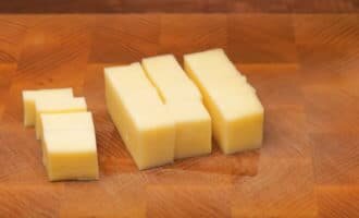 Твердый сыр нарезаем кубиками примерно 1×1 см, по одному для каждого гриба.