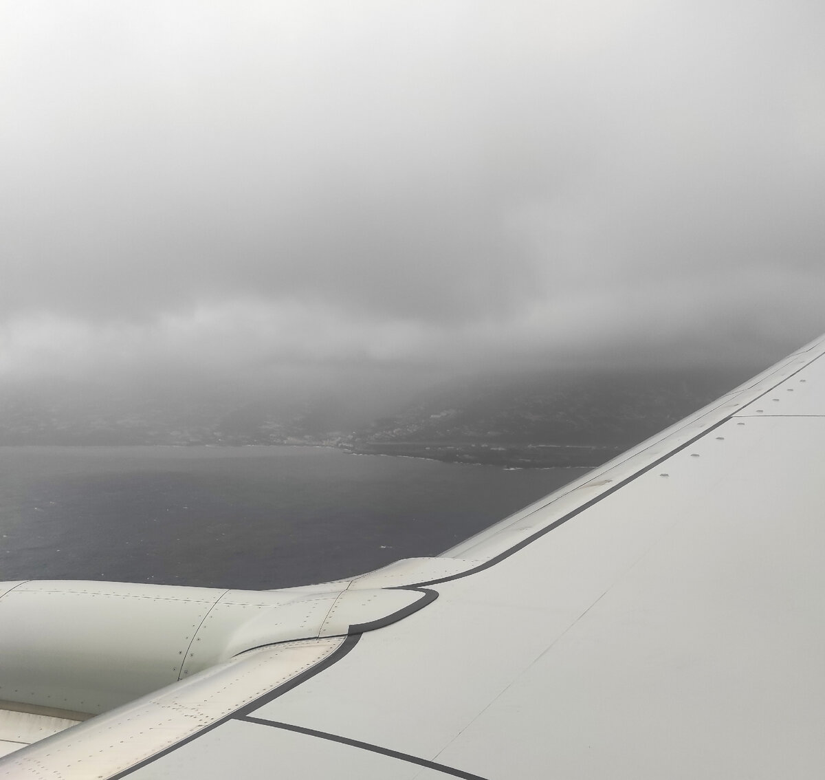 Вид из моего окна на остров, окутанный тучами. Вдали можно разглядеть сигнальные огни полосы