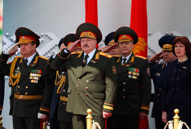 Как это и положено, Лукашенко принимал парад стоя, в отличие от Путина.