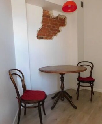 фото стульев и стола: поддержала красный кирпич на стене красным подвесом на потолке и красными подушечками на стульях) 