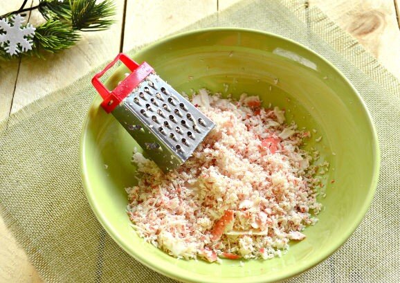 Как приготовить новогоднюю закуску "Елочные шары": 
В подходящую миску натираем крабовые палочки. Часть получившейся крабовой массы оставляем для панировки шариков.