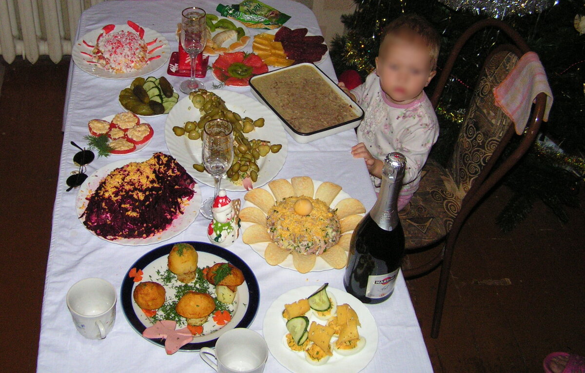 Наш первый Новый год на недостроенной даче. Дети активно "помогали". Младшую "помощницу" поймали на фото. Стол ещё в процессе расстановки блюд, но дети уже тут как тут.