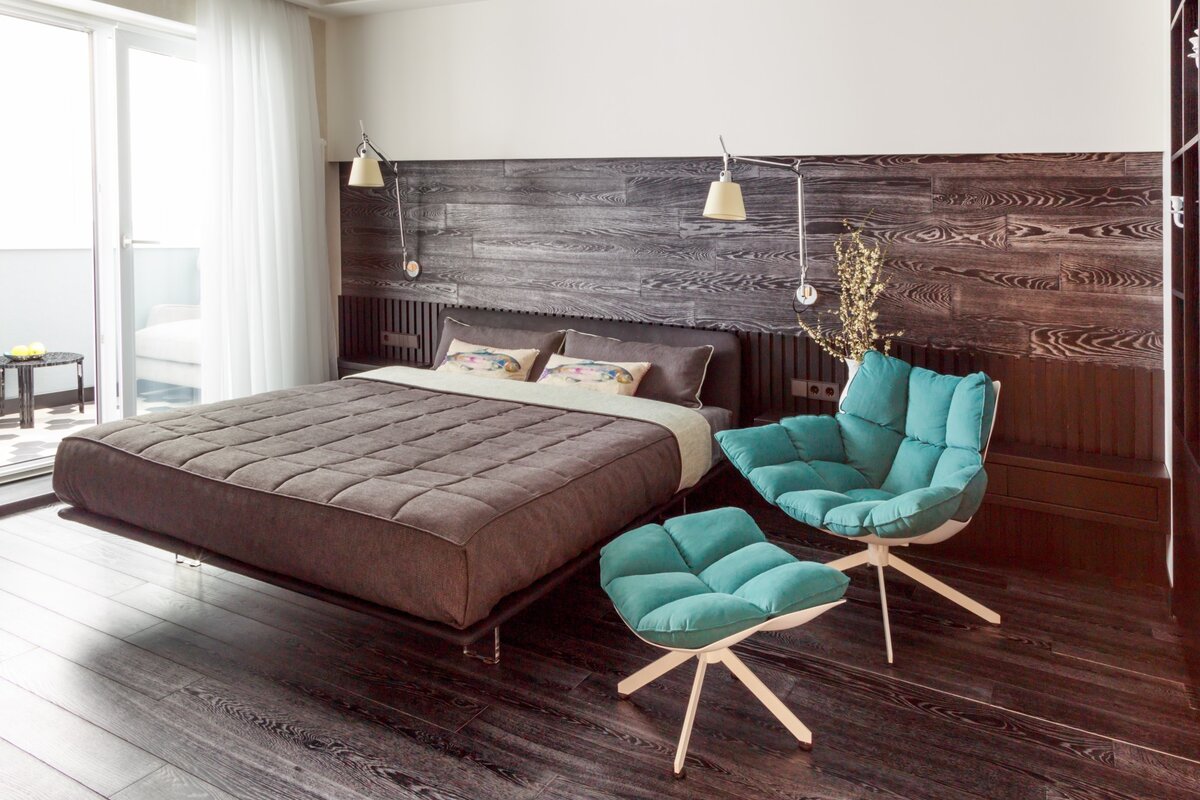 Здесь на стену прикрепили ламинат. Он, как правило, изготавливается на основе МДФ. Он погасит часть шума. 