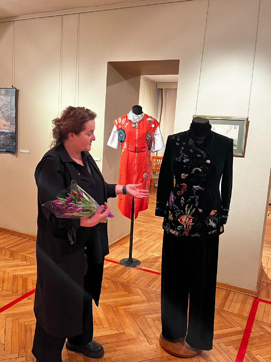 Модельер показывает костюм с вышитым подводным царством 