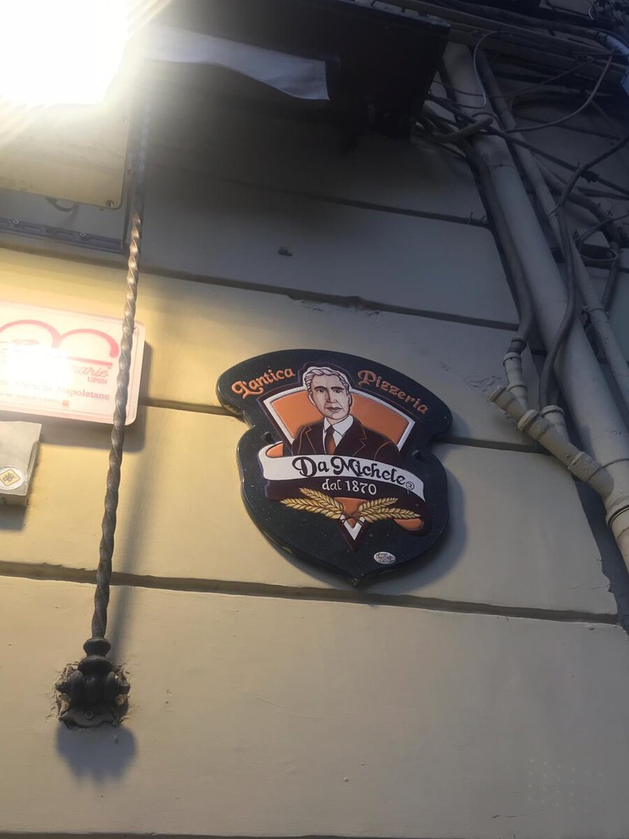 Вывеска пиццерии на стене дома