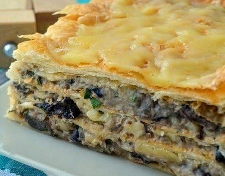 Кто не любит Наполеон?! Мягкий и хорошо пропитанный кремом. А давайте приготовим его немного в другом варианте! Я уверена вы заберёте этот не сложный рецепт в свою копилку!)).   Что нам потребуется?                                      1 упаковка слоёного бездрожевого  теста,   4 картофелины, 150 мл сливок ( чем жирнее,тем вкуснее), 1 крупная луковица, 300 грамм сыра, зелень ( я использую укроп), соль/ перец по вкусу, растительное масло для жарки.                           Приготовление.                                                              Картофель отварить в подсоленной воде. Смять в пюре с добавлением сливок.  Пюре должно получиться не плотным.                 Лук нарезать полукольцами и обжарить его в течение 2-3 минут,до прозрачности. Добавить грибы и жарить пока не уйдет жидкость ( грибы  дают много сока).      Смешать картофель с луком и грибами,добавить мелко нарезанный укроп, соль/ перец по вкусу. Всё хорошо перемешать. Всё! Наша начинка ( крем) готова!                                    Тесто разморозить и раскатать в тонкий пласт. Нарезать. Должно получиться 4 прямоугольника.  Выпекать при температуре 200 градусов, 10-12 минут. Наши коржи должны чуть чуть подрумяниться.      Далее на протвинь ( или в форму , которой вы привыкли пользоваться), кладём первый корж,на него  выкладываем 1/3 часть начинки и посыпаем тёртым сыром, накрываем следующим коржом и так же смазываем начинкой и посыпаем сыром. Последний корж не смазываем ! Только посыпаем сыром.    Ставим в духовку,и выпекаем ещё 5 минут,при той же температуре. Подаём горячим. Это очень вкусно! Приятного вам аппетита! Готовьте с удовольствием!