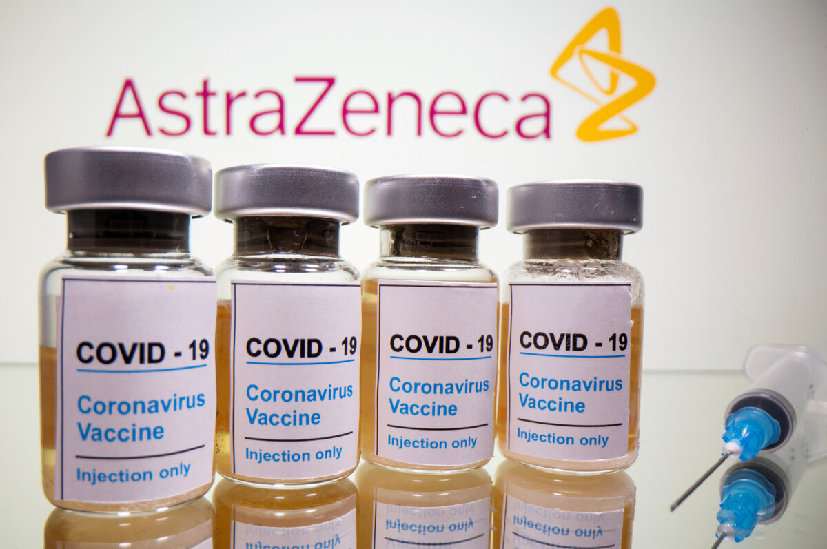 Флаконы  с наклейкой «COVID-19 / вакцина против коронавируса / только для  инъекций» и медицинский шприц видны перед логотипом AstraZeneca на этой  иллюстрации, сделанной 31 октября 2020 г. (Yonhap-Reuters)
