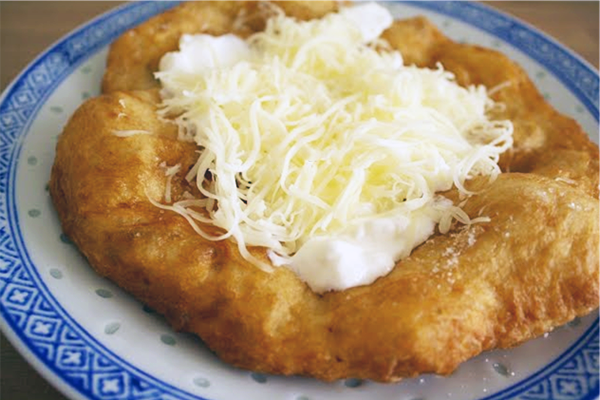 Пышная лепешка лангош с различными начинками - популярная уличная еда в Венгрии