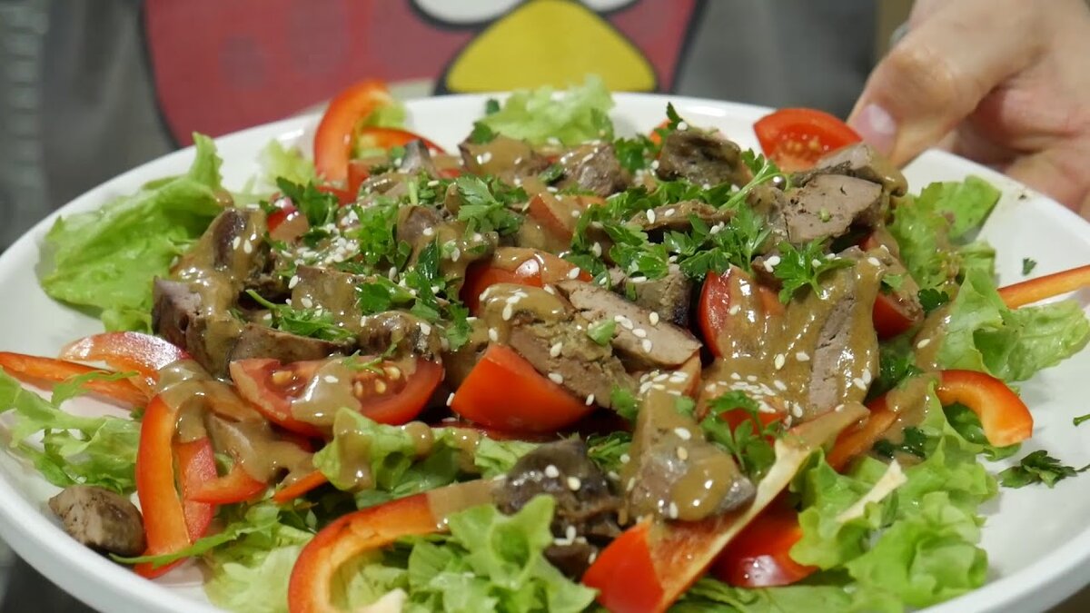  Если Вы любите печень, то я рекомендую попробовать данный салат. Он получается очень нежным и, к слову, ни один наш семейный праздник без него не обходится. Рассказываю, как приготовить вкуснейший салат с куриной печенью! 
Ингредиенты: 
300 грамм по вкусу обжаренной куриной печени 
0,5 банки консервированного горошка 
1 вареное яйцо 
0,5 пучка салата 
1 луковица 
Базилик 
Натуральный цогурт 
1 чайная ложка яблочного уксуса 
1 чайная ложка сахара 
Соль, перец 

Приготовление: 
1. Лук нарежьте полукольцами, залейте холодной водой, смешанной с яблочным уксусом и сахаром 
2. Куриную печень нарежьте, листья салата порвите, яйцо измельчите. 
3. В салатнике смешайте печень, горошек, яйцо, салат, посолите, поперчите и заправьте салат натуральным йогуртом. Перед подачей дополните салат маринованным луком и базиликом. 

Приятного аппетита!